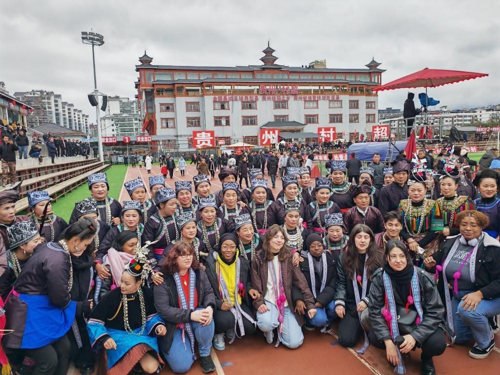 法國青年在“村超”賽場(chǎng)邊與參加表演的村民合影。新華社記者 羅羽 攝