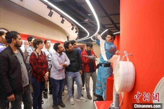 5月9日，工作人員指導(dǎo)留學(xué)生正確使用消防水帶。張鷹 攝