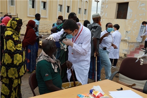 在義診現(xiàn)場，中國醫(yī)生與當(dāng)?shù)鼐用窈嫌傲裟?，吉布提鹽業(yè)投資公司供圖