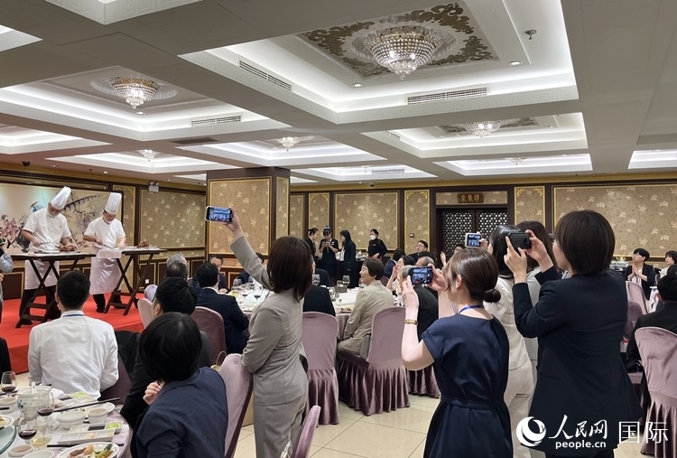 國家級非物質(zhì)文化遺產(chǎn)、全聚德片鴨工藝吸引代表團成員拍照留念。