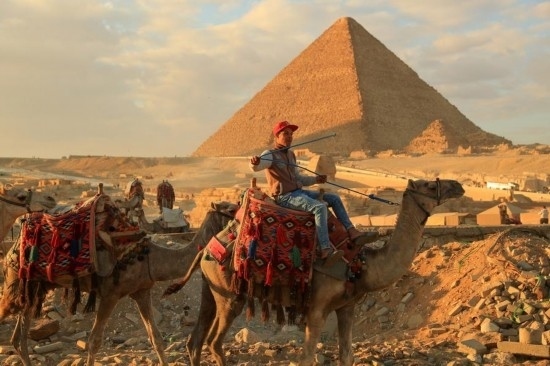 1月24日，商販騎駱駝離開埃及吉薩金字塔景區(qū)。新華社記者 隋先凱 攝