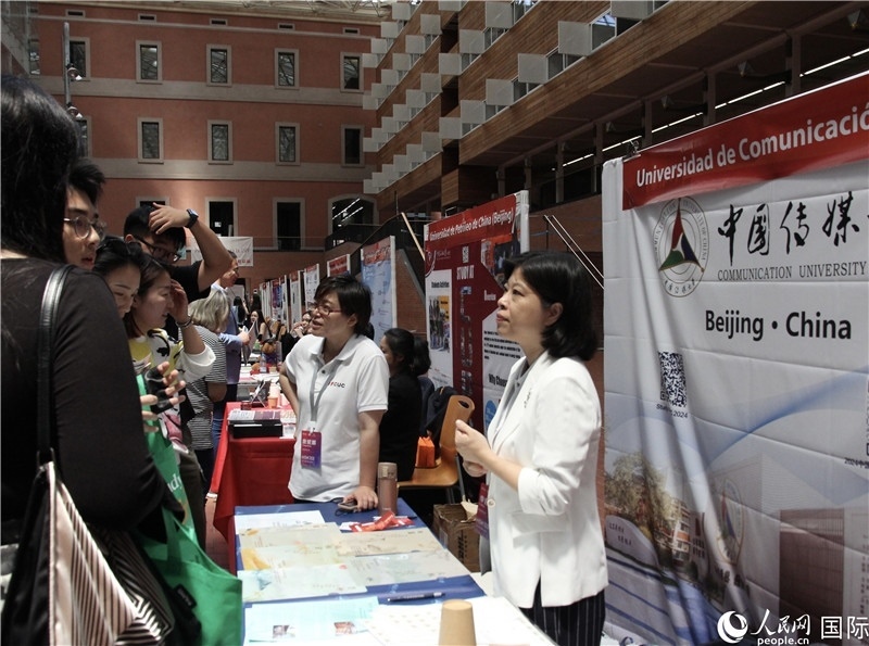 旅西華人華僑在展臺前咨詢。人民網(wǎng)記者 許海林?jǐn)z