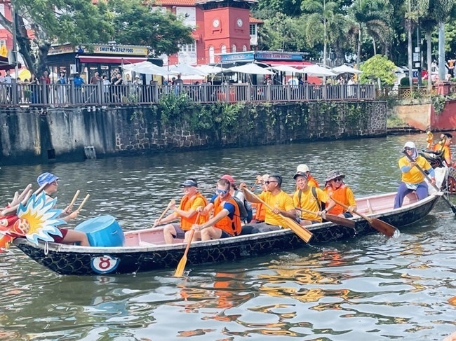 多元種族共同奮輯前進(jìn)，體驗在馬六甲河劃龍舟，引來大批游客駐足圍觀。組委會供圖