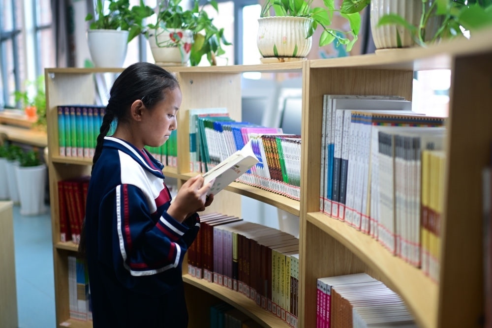 6月18日，果洛西寧民族中學(xué)學(xué)生尼東拉毛在圖書室看書。