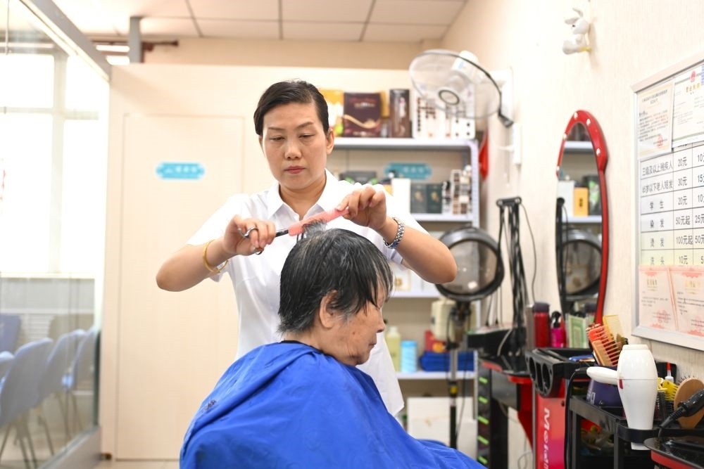 6月20日，長(zhǎng)城花園社區(qū)的志愿者為居民理發(fā)。