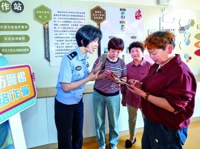 浙江湖州民警指導(dǎo)居民加入湖州“e企安”微信群，實(shí)時(shí)接收反詐信息。新華社發(fā)