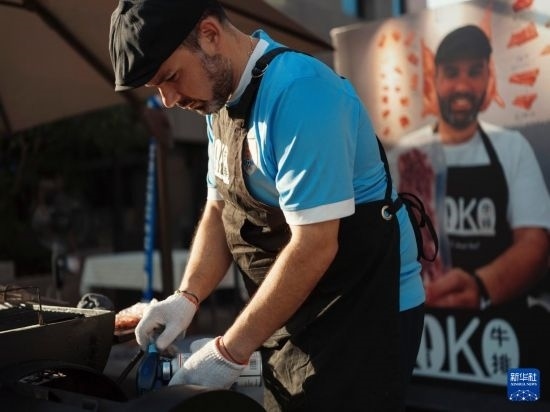 7月19日，在蕪湖古城，馬丁在當(dāng)天舉行的啤酒節(jié)上制作牛排。新華社發(fā)（繆雨晨 攝）