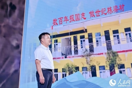 張玉滾分享用一根扁擔(dān)送孩子們走出大山的故事。人民網(wǎng)攝