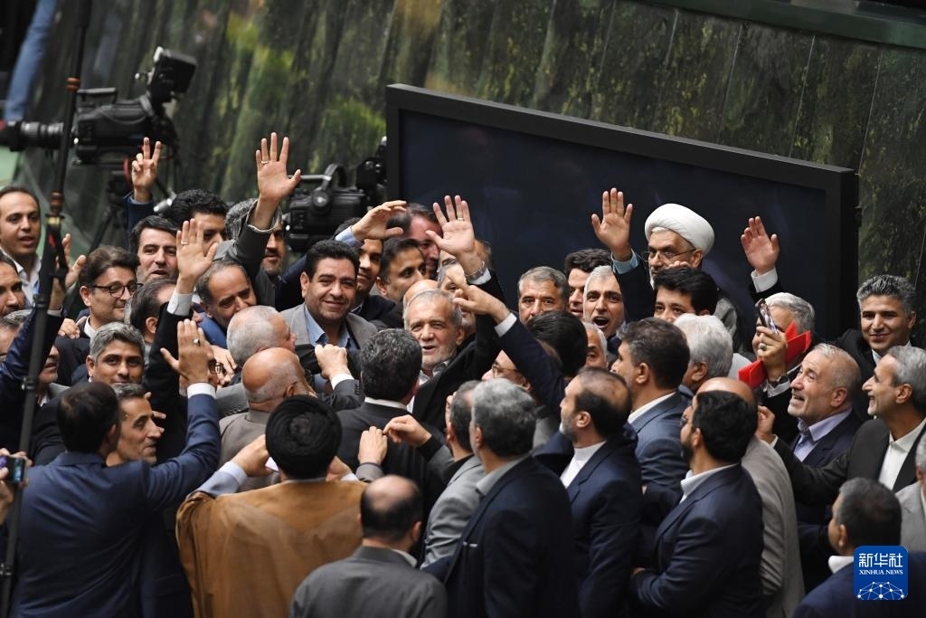 7月30日，在伊朗德黑蘭的伊朗議會(huì)，佩澤希齊揚(yáng)（中）離開(kāi)總統(tǒng)就職典禮現(xiàn)場(chǎng)時(shí)揮手致意。新華社記者 沙達(dá)提 攝