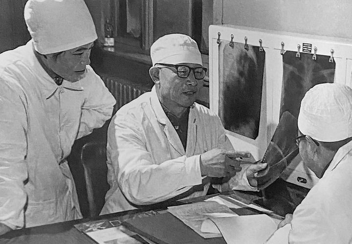 1980年1月16日，中日友好醫(yī)院首任院長(zhǎng)辛育齡（中）在內(nèi)蒙古結(jié)核病院與胸外科醫(yī)師討論病例（翻拍照片）。 新華社發(fā)