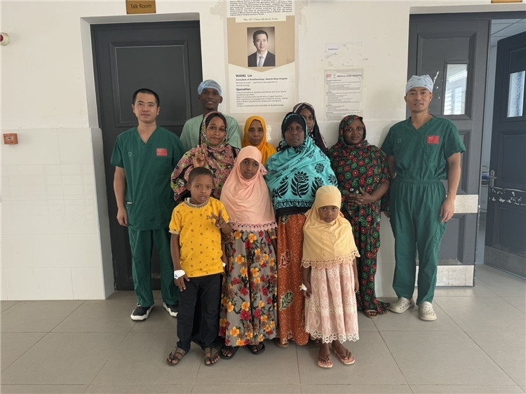 李廣（右一）和王林醫(yī)生與部分患者合影。中國(guó)援桑醫(yī)療隊(duì)供圖