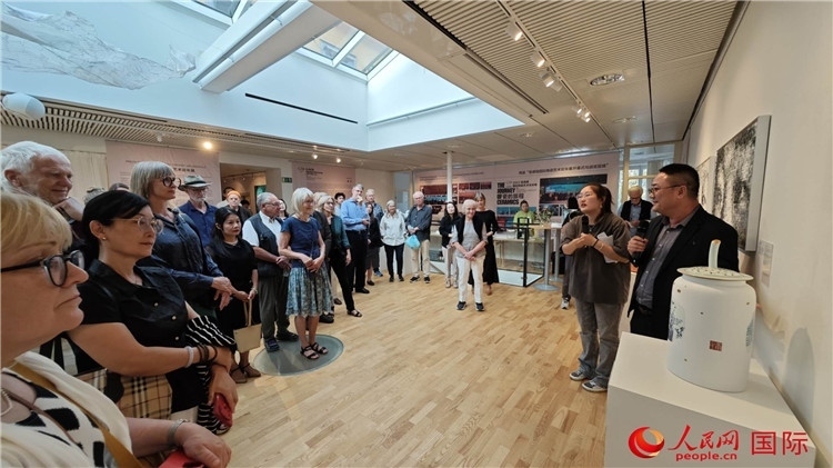 參展人、景德鎮(zhèn)陶瓷大學美術(shù)學院副院長邵長宗（右一）向來賓介紹參展作品。人民網(wǎng)記者 殷淼攝