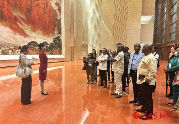 代表團在入口處聽取講解。人民網(wǎng) 曹欣悅攝