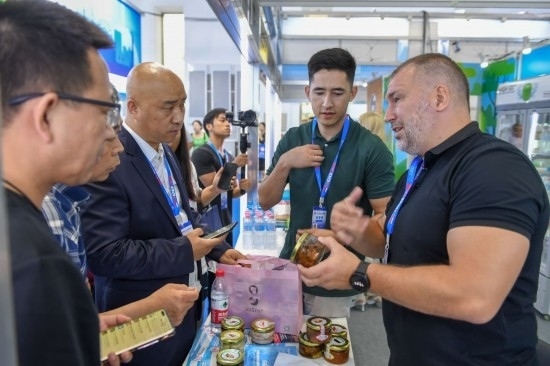 2023年8月23日，在第十四屆中國(guó)—東北亞博覽會(huì)東北亞商品館，俄羅斯參展商向參觀者介紹商品。