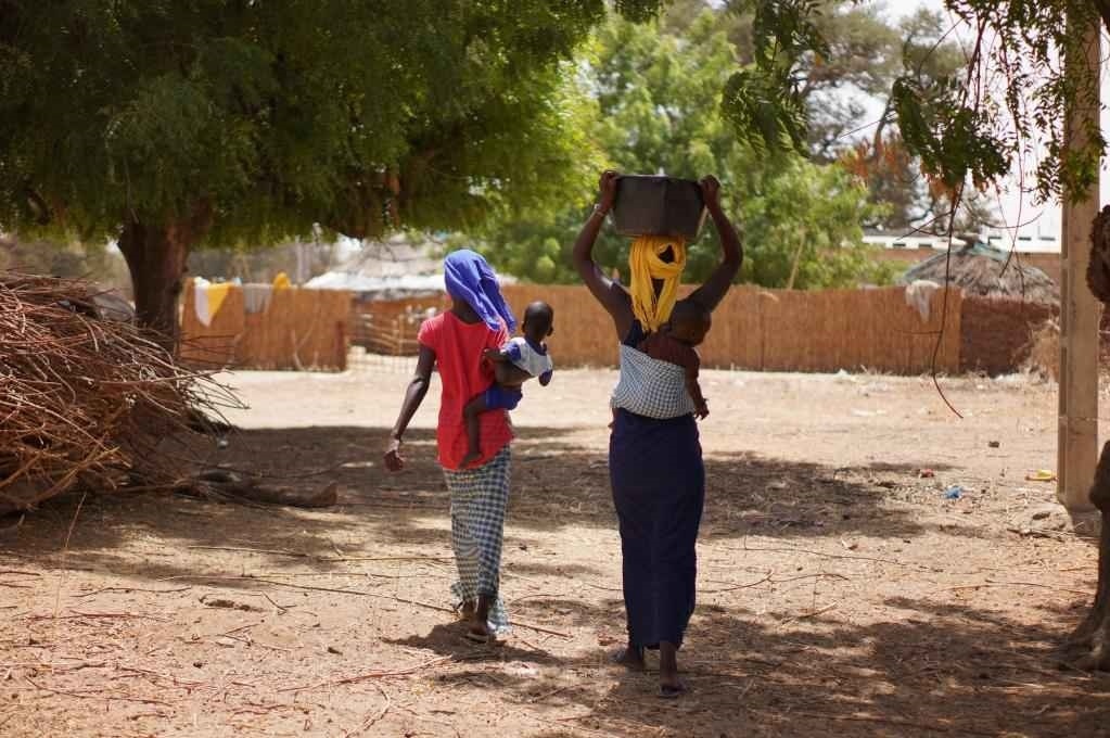 2023年3月20日，在塞內(nèi)加爾久爾貝勒區(qū)的泰內(nèi)富勒村，村民將取到的水運回家。新華社記者 王子正 攝