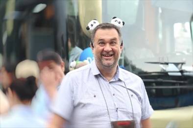 參訪熊貓谷前，塞爾維亞“一帶一路”研究所所長博揚(yáng)·拉利奇戴上熊貓頭飾。（李佩藺 攝）