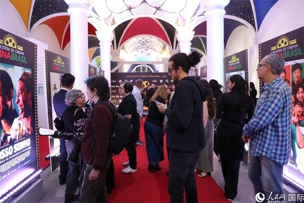 為期4天的第三屆中國(guó)－巴西電影展期間，來(lái)自中巴兩國(guó)的14部參展影片受到巴西電影愛(ài)好者和社會(huì)各界人士好評(píng)，圖為當(dāng)?shù)赜^(guān)眾在影展舉辦地巴西里約熱內(nèi)盧勞拉—阿爾維姆文化之家的迎賓廳欣賞參展電影海報(bào)。 人民網(wǎng)記者 陳一鳴攝