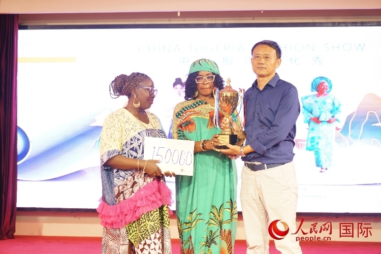 中國(guó)駐尼日利亞使館文化參贊兼中國(guó)文化中心主任李旭大（右）為最佳表現(xiàn)獎(jiǎng)?lì)C獎(jiǎng)（中）。人民網(wǎng)記者 姜宣攝