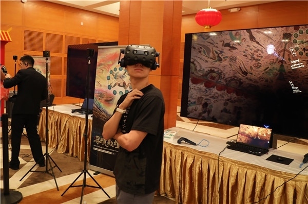 1、在本次活動的展覽現(xiàn)場，敦煌研究院與騰訊展示了“數(shù)字藏經(jīng)洞”和“尋境敦煌”等創(chuàng)新互動產(chǎn)品。圖為當?shù)孛癖娡ㄟ^VR虛擬游覽洞窟。 人民網(wǎng)記者 李志偉攝