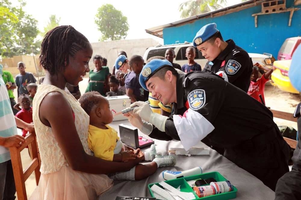 2017年12月28日，在利比里亞蒙羅維亞，中國(guó)維和警察防暴隊(duì)醫(yī)療人員為兒童做口腔檢查。
