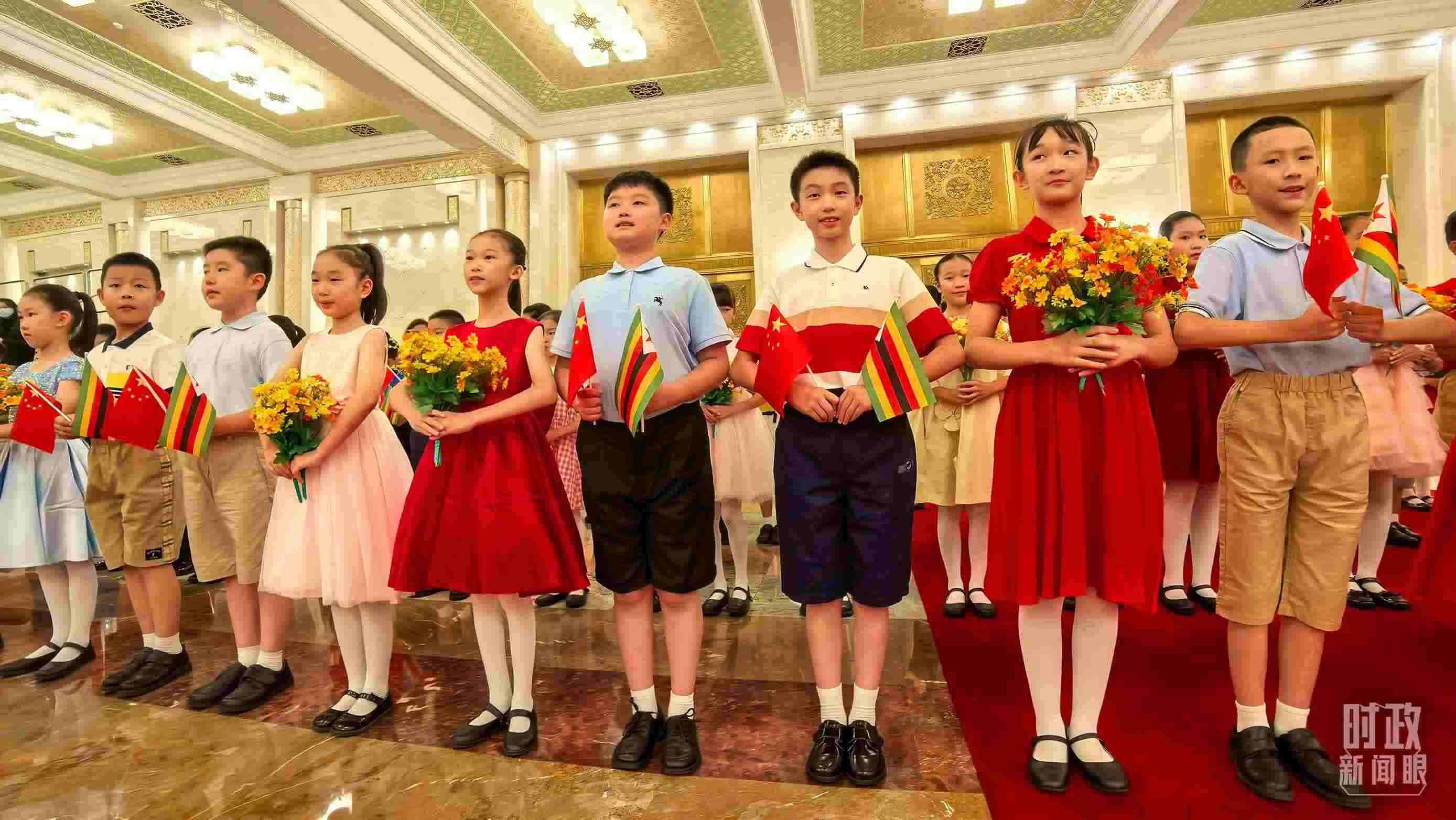 △現(xiàn)場歡迎津巴布韋總統(tǒng)訪華的青少年。（總臺(tái)央視記者鐘銳拍攝）