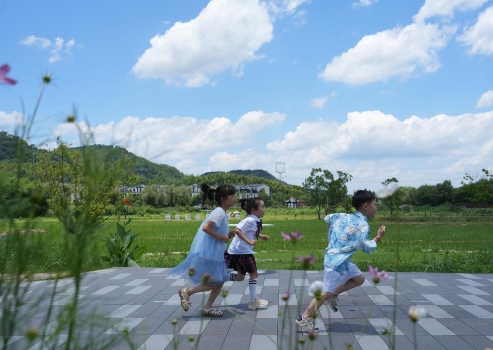 兒童在余姚市梁弄鎮(zhèn)的田野間奔跑（7月3日攝）。新華社記者翁忻旸 攝