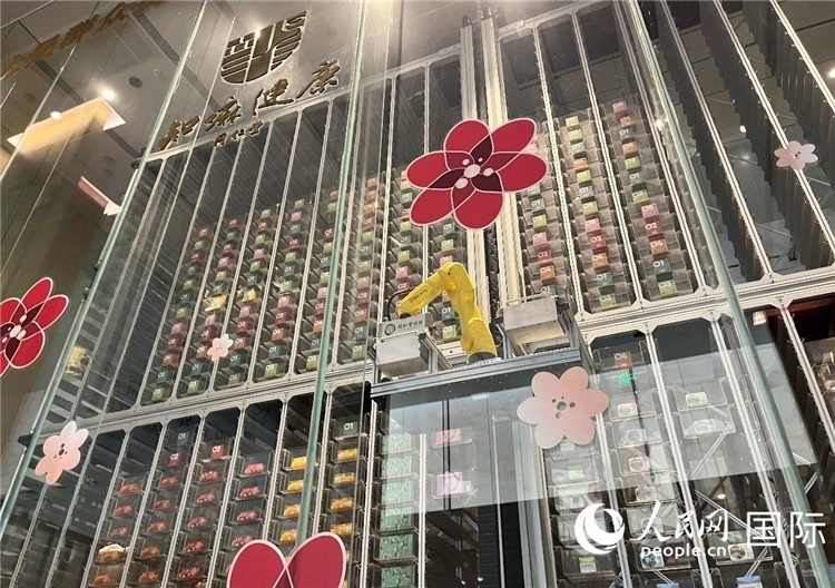 6. 機(jī)械臂正在取貨。（人民網(wǎng)記者陳思 攝）