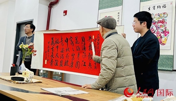 旅秘書法家向現(xiàn)場(chǎng)觀眾展示書法作品。人民網(wǎng)記者 宋亦然攝