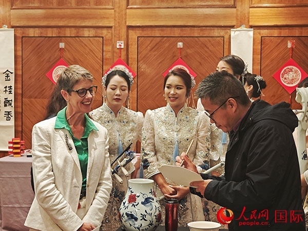 現(xiàn)場的非遺傳承人為英國觀眾展示畫技。人民網(wǎng)記者 邢雪攝