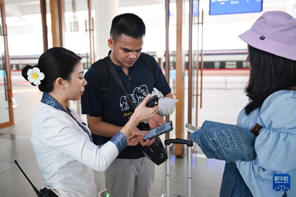 10月12日，在老撾萬象中老鐵路萬象站，工作人員檢驗乘客車票。新華社記者 程一恒 攝