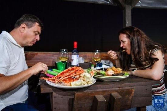 9月2日，食客們?cè)诙砹_斯符拉迪沃斯托克的一家餐館品嘗帝王蟹。新華社記者 曹陽(yáng) 攝