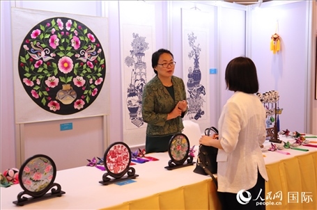 青海非遺文化傳承人向嘉賓介紹展品。人民網(wǎng)實習(xí)生姚欣可攝