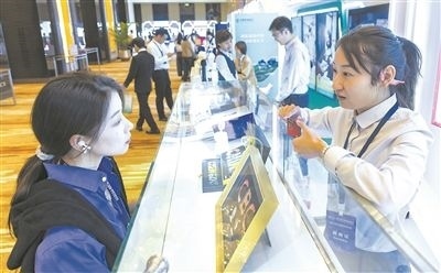 在北京麗澤商務(wù)區(qū)，工作人員（右一）介紹數(shù)字人民幣SIM卡硬錢包。新京報(bào)記者 陶冉攝