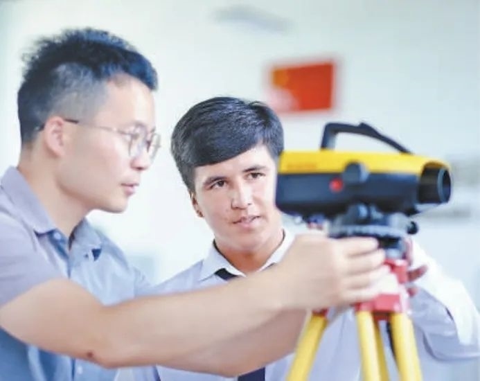 在塔吉克斯坦首都杜尚別的魯班工坊，來(lái)自天津城市建設(shè)管理職業(yè)技術(shù)學(xué)院的老師（左）為當(dāng)?shù)貙W(xué)生提供指導(dǎo)。新華社記者 鄭開(kāi)君 攝