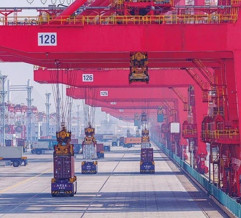 共建“一帶一路”國(guó)家在工作制度對(duì)接、技術(shù)標(biāo)準(zhǔn)協(xié)調(diào)、檢驗(yàn)結(jié)果互認(rèn)等方面強(qiáng)化合作、統(tǒng)一標(biāo)準(zhǔn)，貿(mào)易自由化便利化水平不斷提升。上海洋山港海關(guān)對(duì)接共建國(guó)家進(jìn)出口貨物相關(guān)標(biāo)準(zhǔn)，推動(dòng)通關(guān)一體化方式申報(bào)，提升通關(guān)效率。圖為無(wú)人駕駛的全自動(dòng)導(dǎo)引車(chē)在洋山港穿梭往來(lái)，搬運(yùn)集裝箱。王初 攝