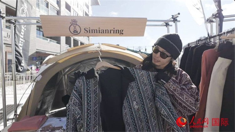 藤田周正在展示自己設(shè)計(jì)的滑雪服。人民網(wǎng)記者 袁蒙攝