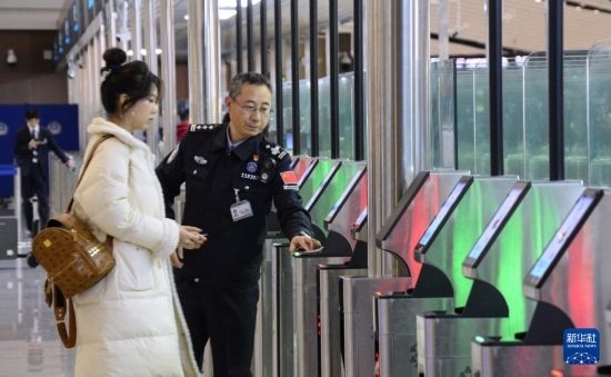 1月2日，大興機(jī)場邊檢站警察指導(dǎo)旅客使用自助出境設(shè)備。新華社記者 李欣 攝