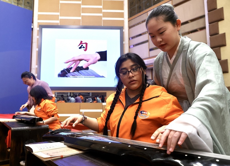 2024年3月20日，美國華盛頓州中學生代表團北京大學交流活動在北京大學英杰交流中心舉行。圖為來自華盛頓州的中學生體驗古琴。