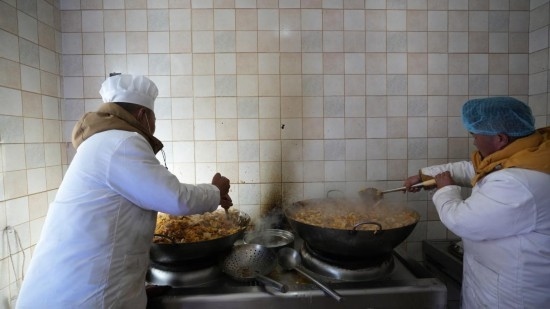 1月14日，服務(wù)隊的兩名廚師正在為村民們做午飯。新華社記者 邱星翔 攝