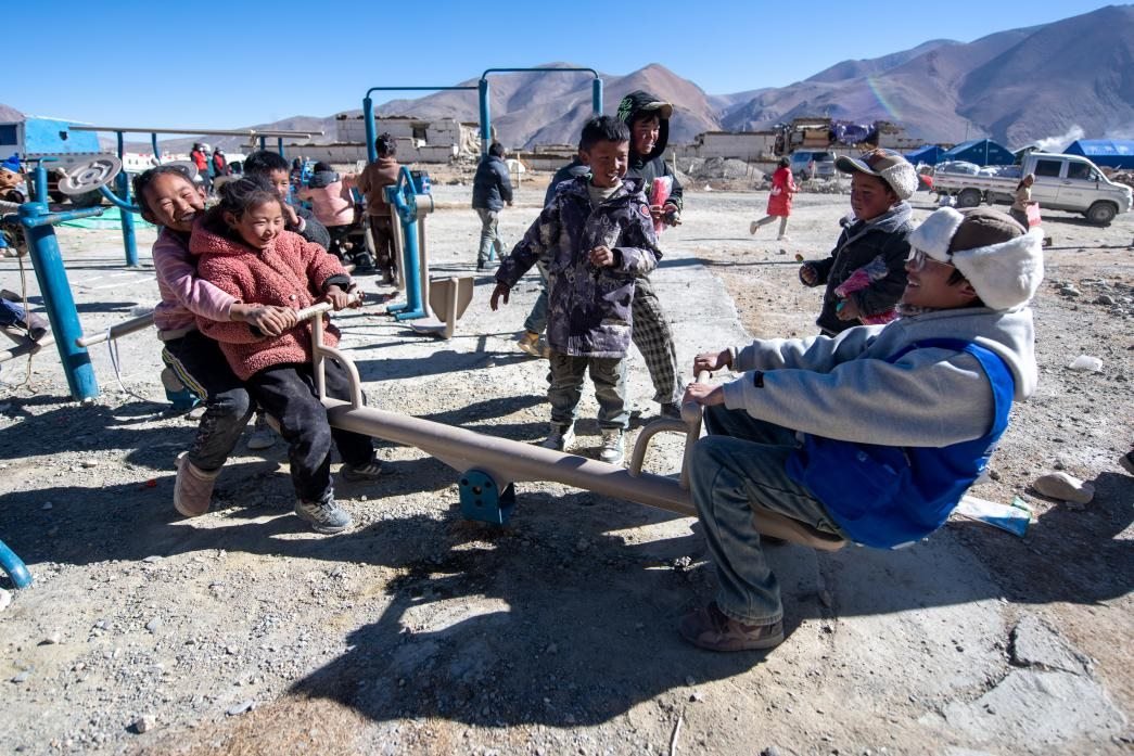 1月11日，在定日縣措果鄉(xiāng)塘仁村安置點，西藏星光社會工作服務(wù)中心志愿者和孩子們一起玩耍，進(jìn)行災(zāi)后心理疏導(dǎo)。人民網(wǎng)記者 翁奇羽攝