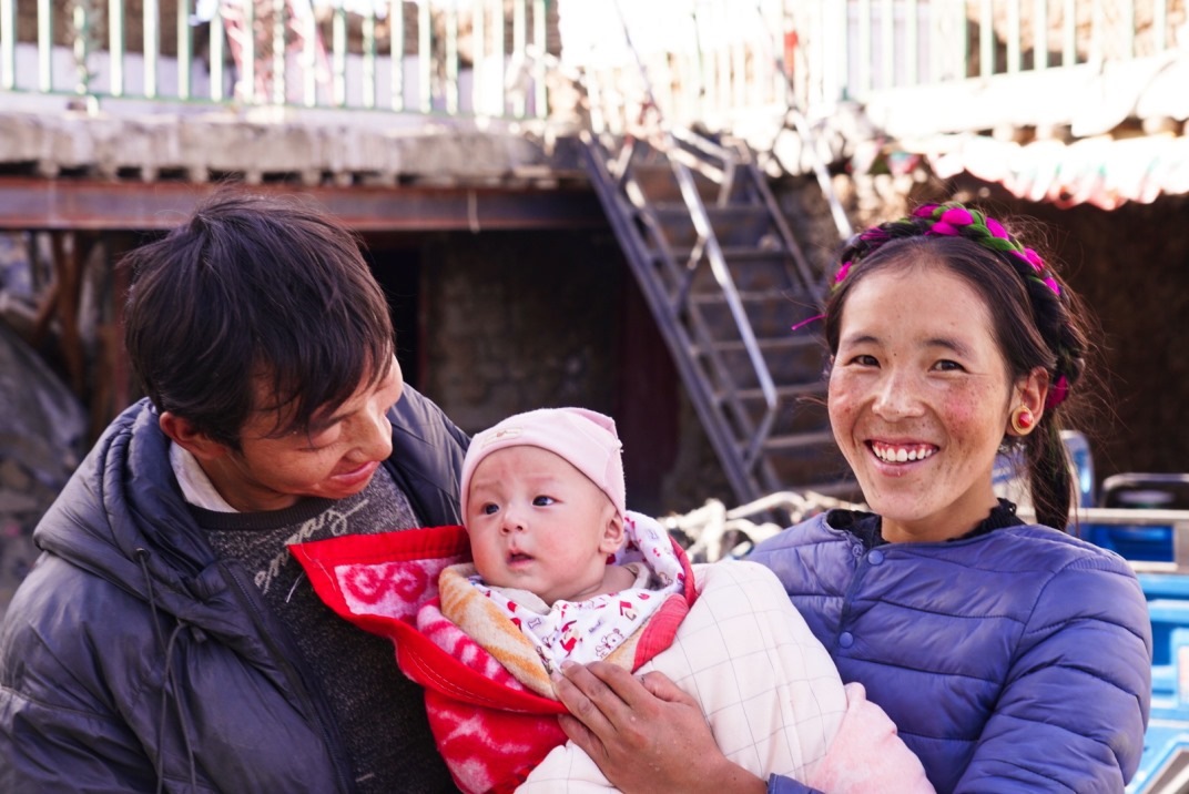 1月11日，在西藏日喀則市人民醫(yī)院，受災(zāi)群眾抱著自己在地震中受傷的孩子康復(fù)出院。人民日報記者徐馭堯攝