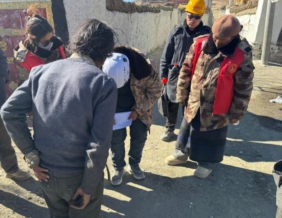 1月13日，次旺（右一）陪同工作組走訪村莊，評估房屋受損程度。新華社發(fā)