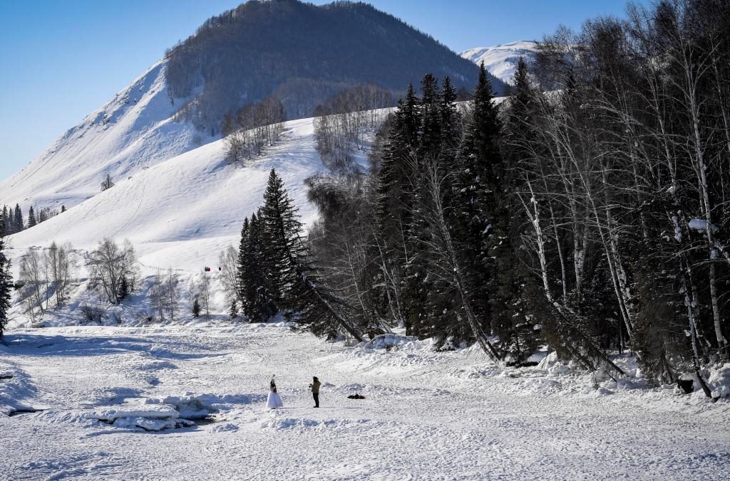 2024年2月5日，兩名游客在新疆阿勒泰地區(qū)布爾津縣禾木村拍照。新華社記者 馬鍇 攝