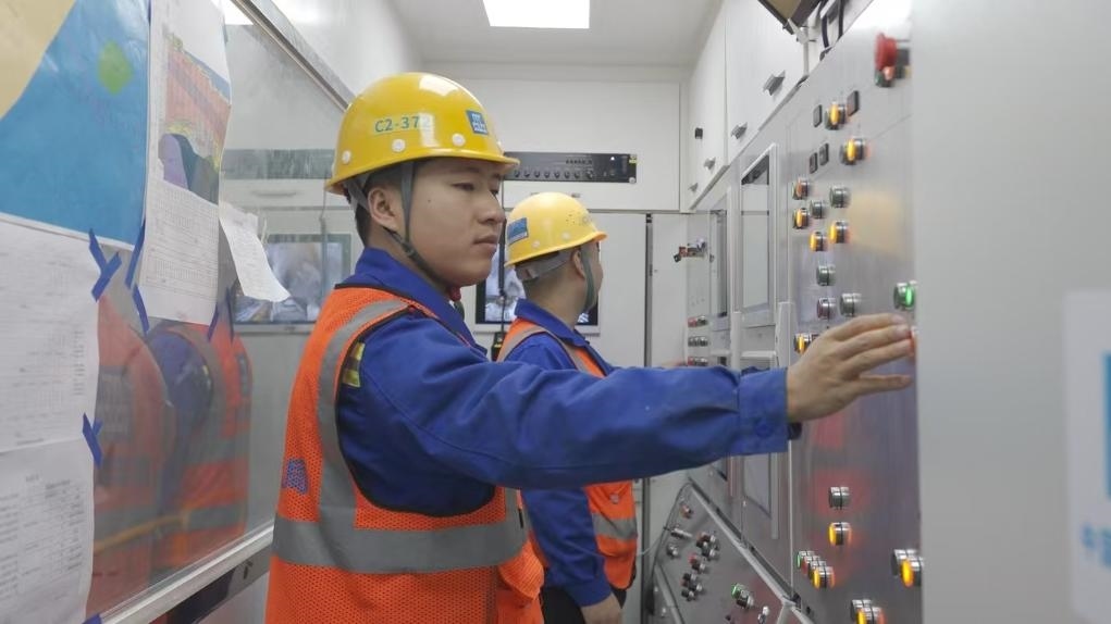 盾構(gòu)司機(jī)何曉波在駕駛室內(nèi)調(diào)試盾構(gòu)機(jī)參數(shù)。（劉芬攝）