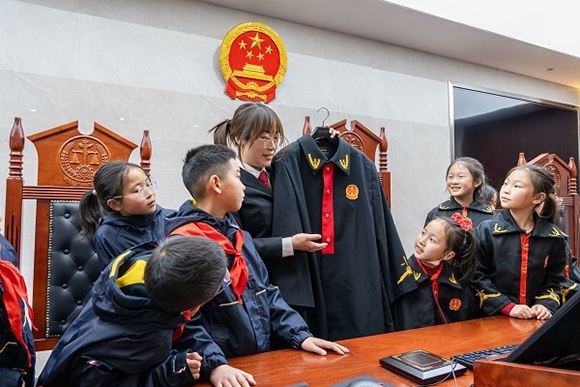 圖②：干警向同學們介紹法袍。