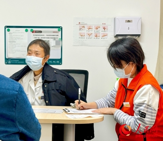 秦苑（中）接診患者。人民網記者 金慧慧攝