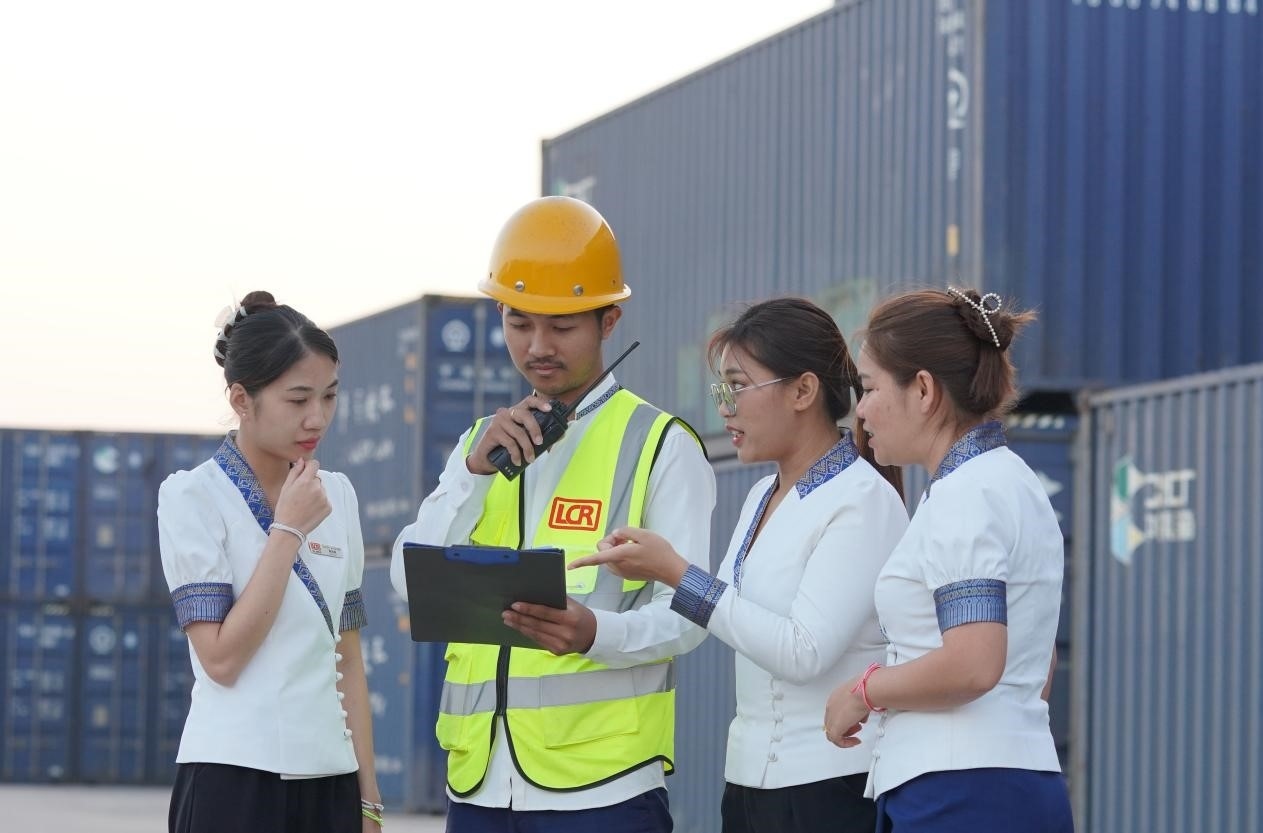 萬象南站貨運(yùn)值班員陳尼啦（左一）與同事在一起討論工作。老中鐵路有限公司供圖