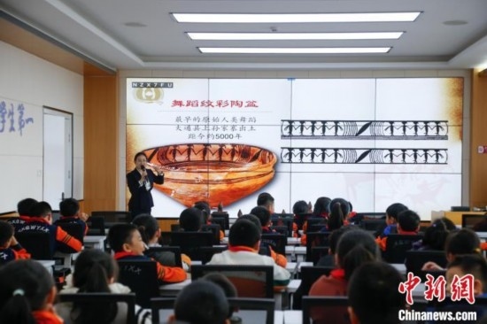 圖為學(xué)生在“國寶音樂會(huì)”社教課中了解舞蹈紋彩陶盆。中新社記者 馬銘言 攝
