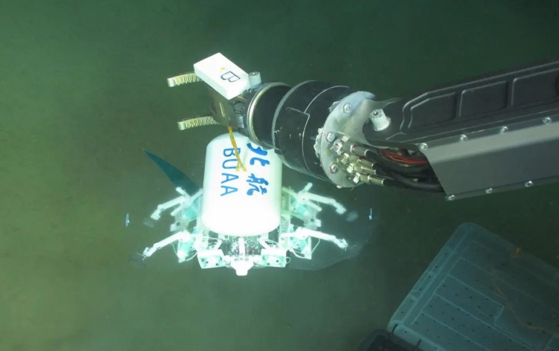 科研人員利用機(jī)械臂將北航深海小型機(jī)器人投于馬里亞納海溝。校方供圖