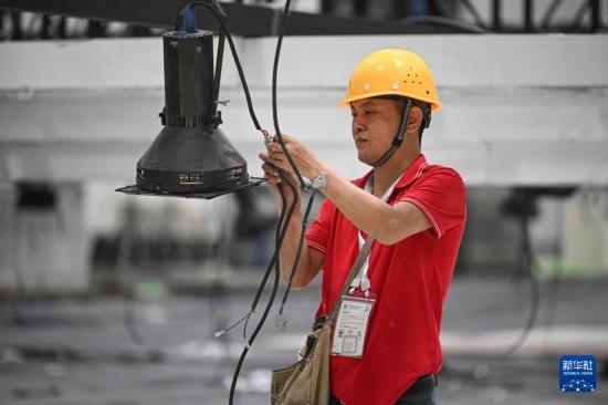 4月4日，工作人員在海南國(guó)際會(huì)展中心內(nèi)布設(shè)燈光。